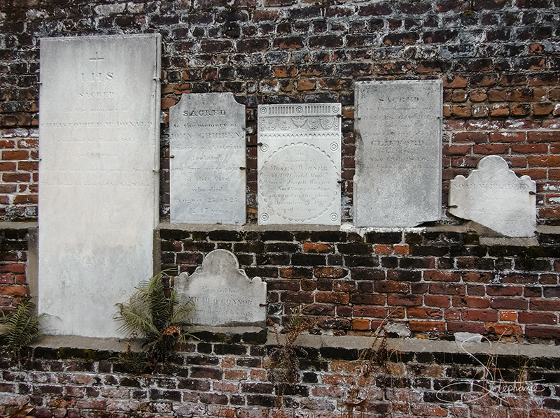 Headstones on a wall at Colonial Park Cemetery, Savannah, Georgia.