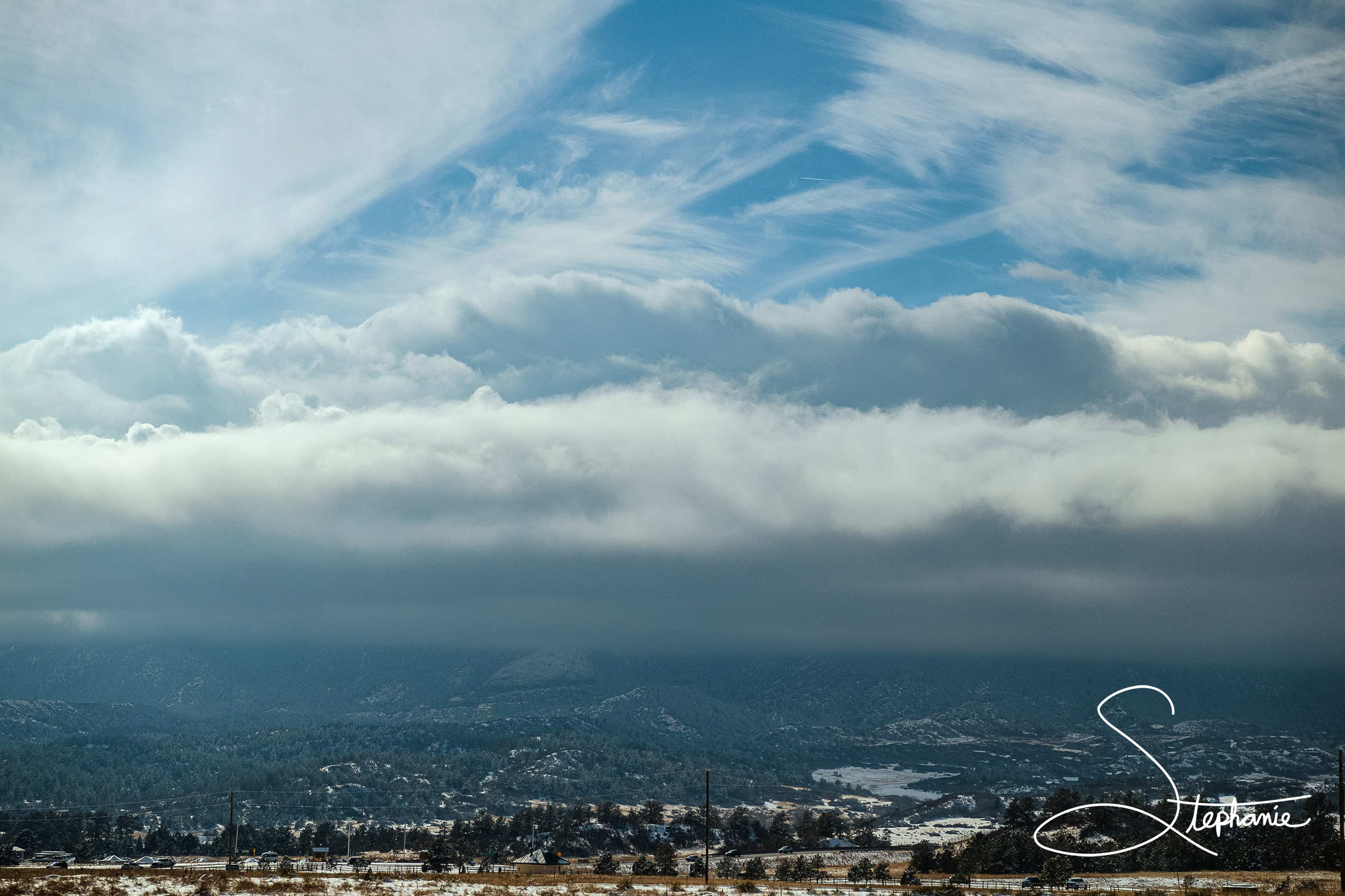 Photo of the horizon showing blues skies above the clouds and rain beneath. Taken in Colorado.
