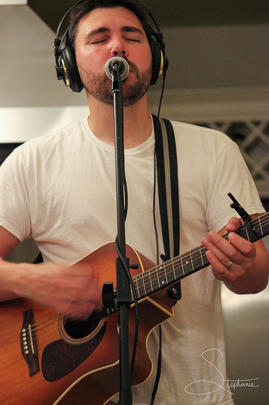 A man playing guitar during a recording session.