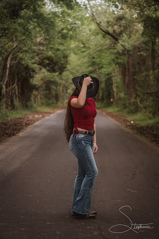 Photo of a cowgirl on a desolate road.