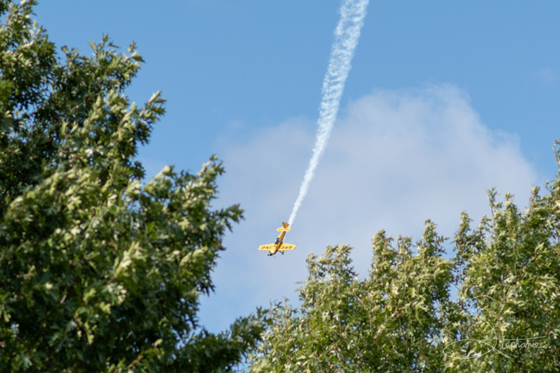 A yellow plane doing stunts at the Fort Worth Alliance Air Show.